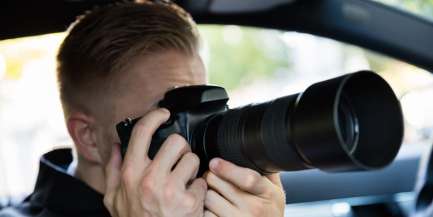Observation durch einen Detektiv mit Kamera