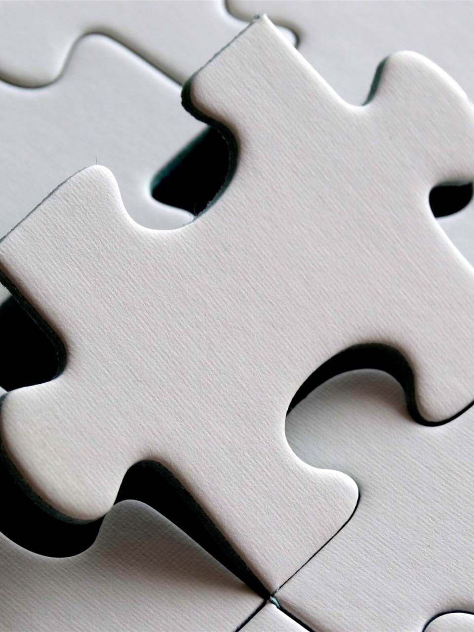 Ein weißes Puzzle, in das das letzte fehlende Element eingefügt wird.