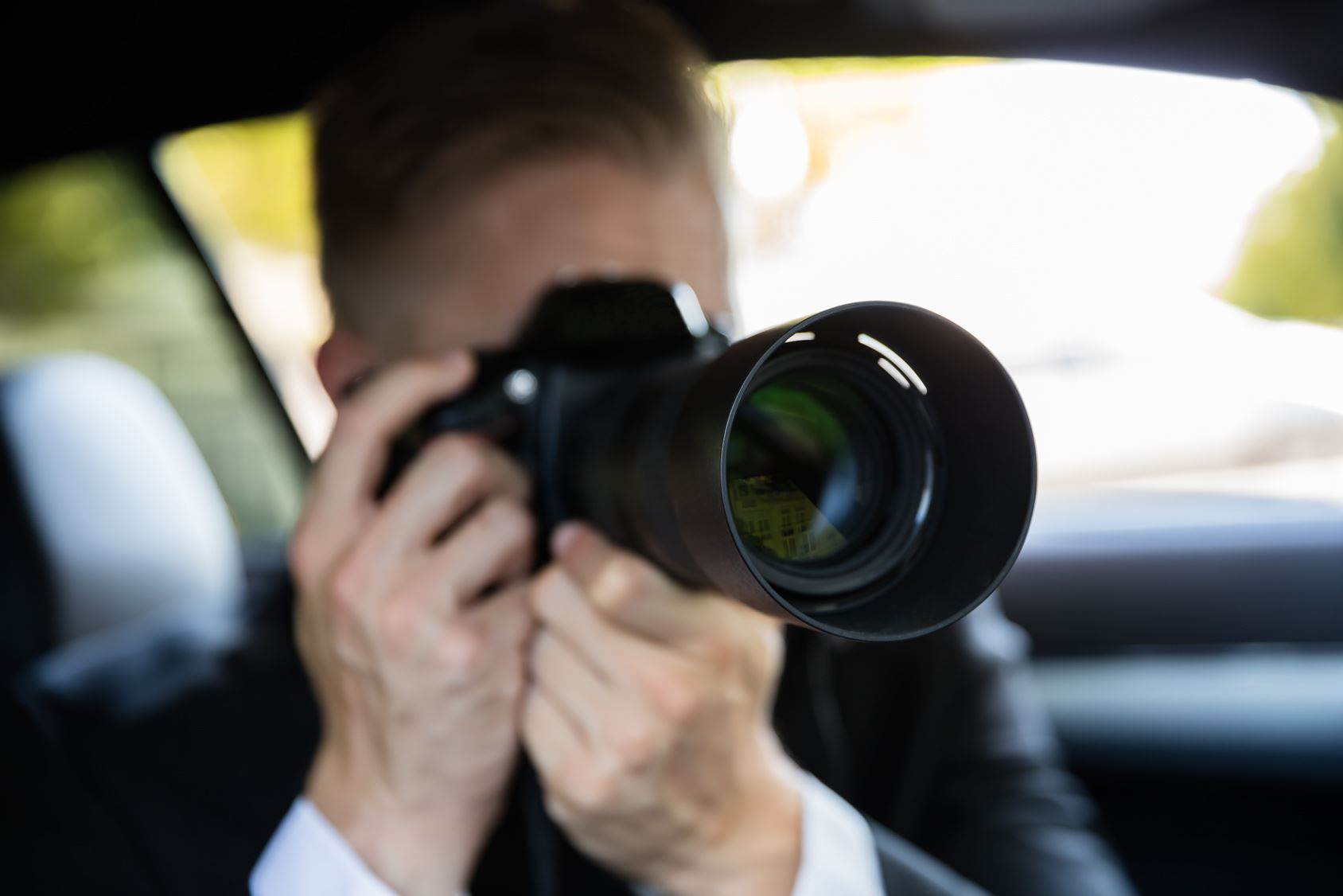 Ein Detektiv fotografiert aus einem Auto heraus