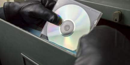 Dieb stiehlt eine CD aus einem Aktenschrank