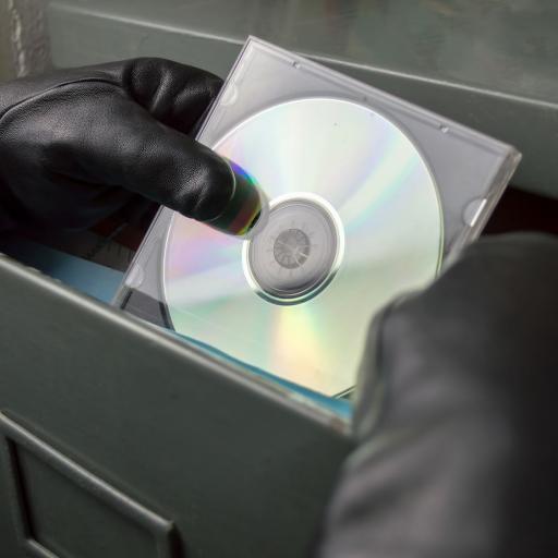 Dieb stiehlt eine CD aus einem Aktenschrank