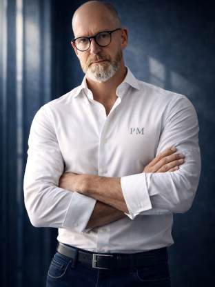 Paul H. Malberg recherchiert Personen und Adressen. Er steht frontal vor der Kamera im weißen Hemd und blauer Jeanshose